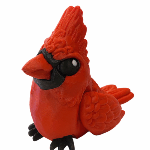 3D-printed red cardinal figurine with detailed feathers and black accents, sitting upright on a white background.